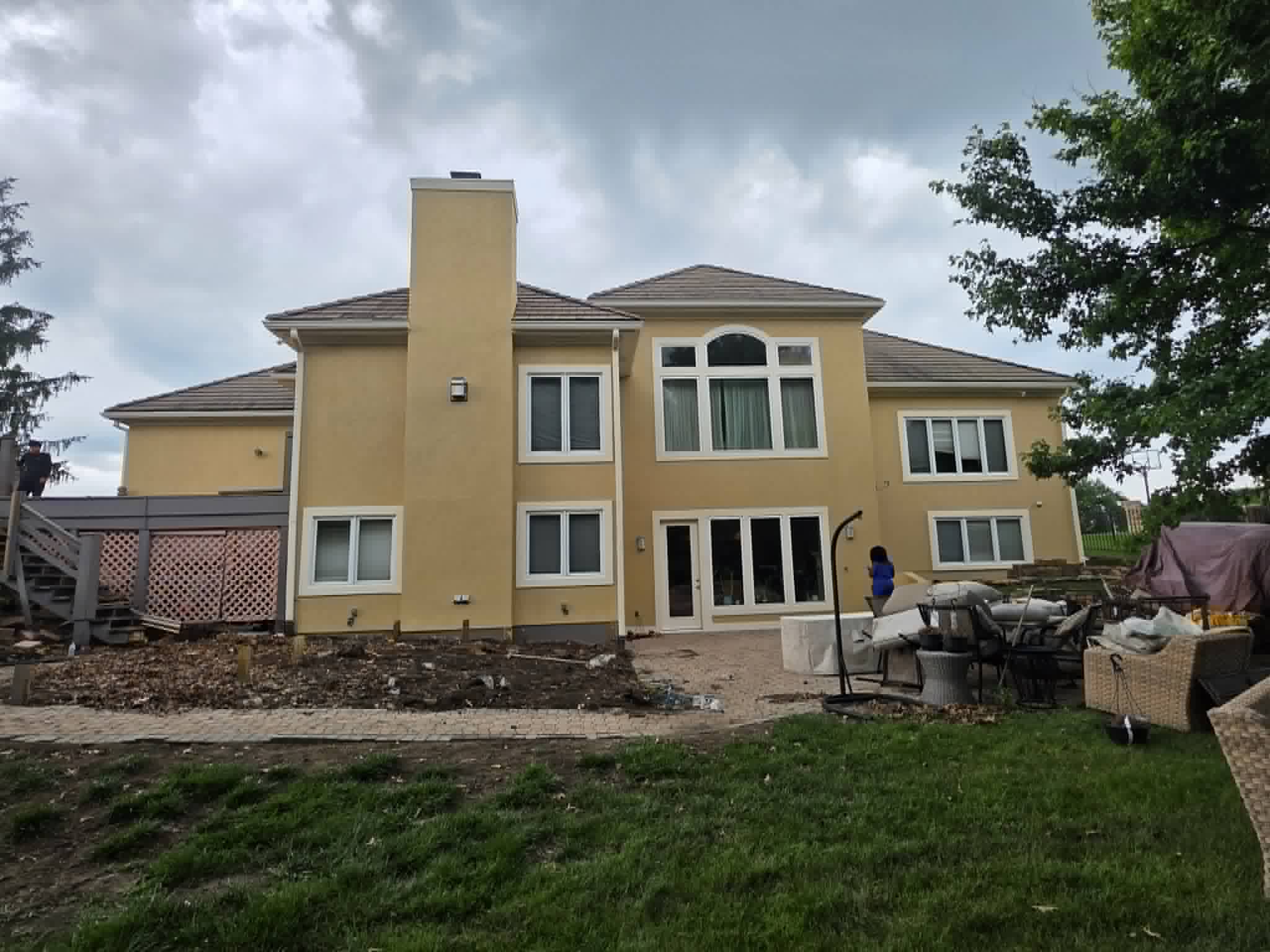 Back of a two-story home freshly painted yellow with white trim