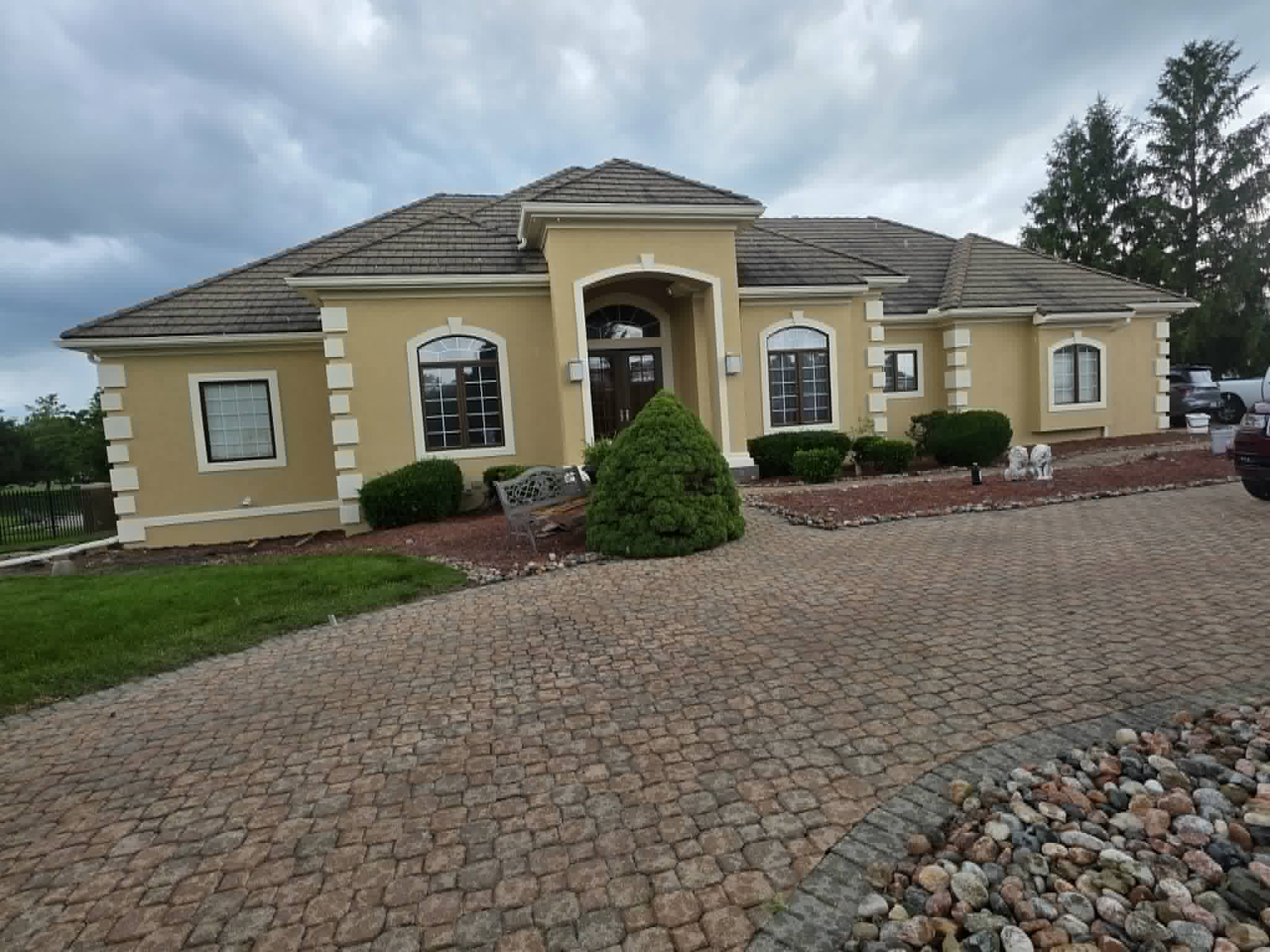 The same estate freshly painted warm yellow with crisp white trim