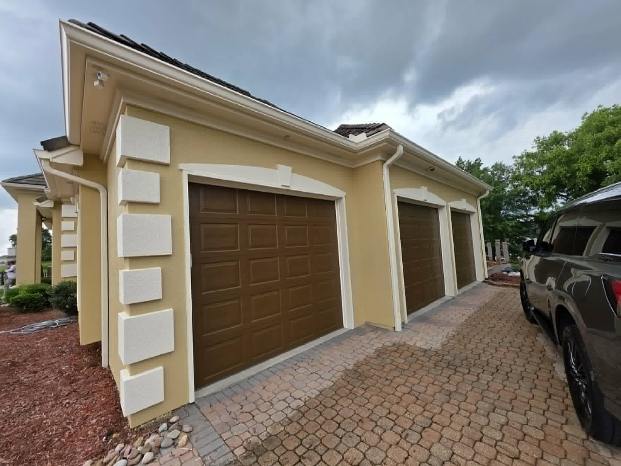 Garage wing repainted yellow with white quoins and rich brown doors