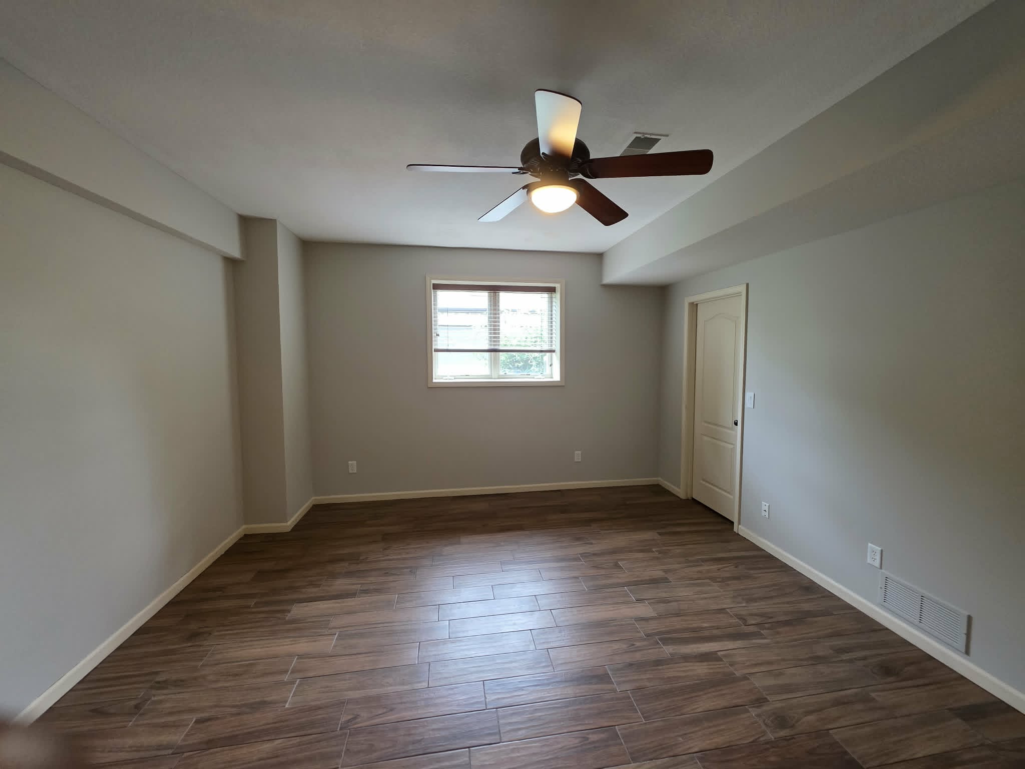 The same bedroom repainted in a bright light gray