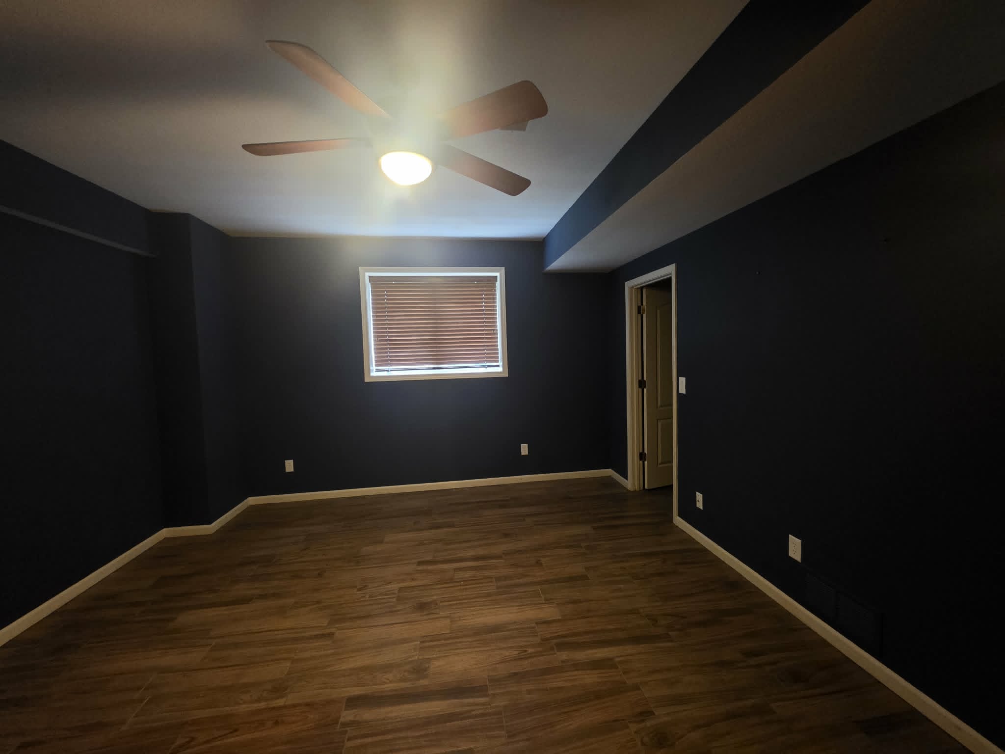 Bedroom with dark navy walls before repainting