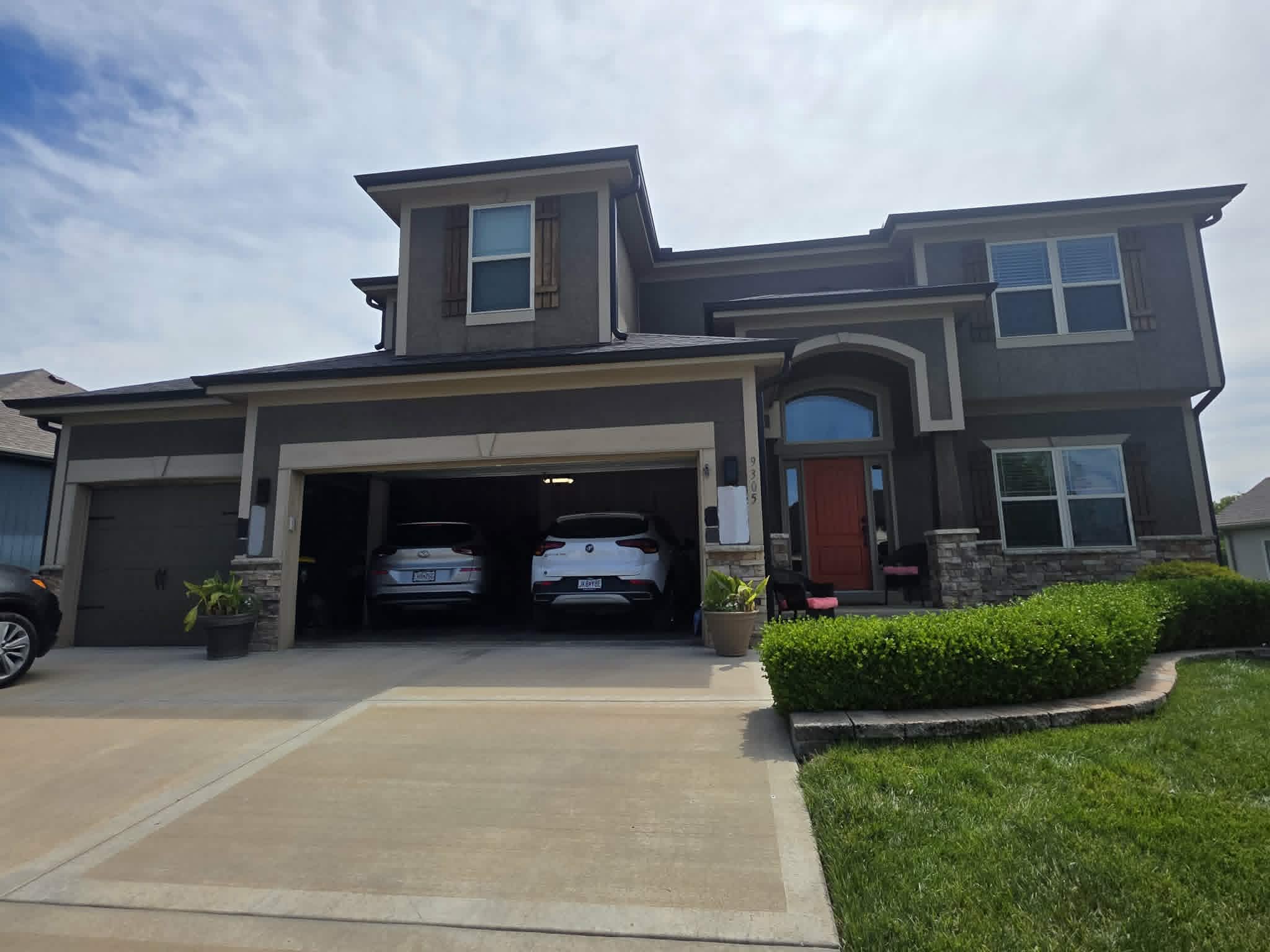 Two-story home in dated tan stucco before repainting